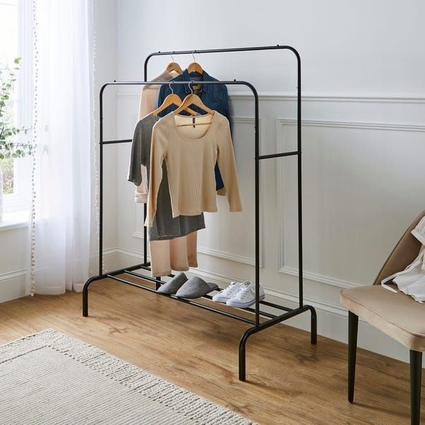 Minimalistisk klädställning med neutrala plagg och skor i ett ljust rum